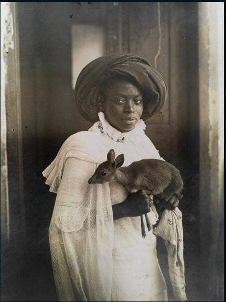 Young Kenyan woman holds her pet deer in Mombassa, March 1909